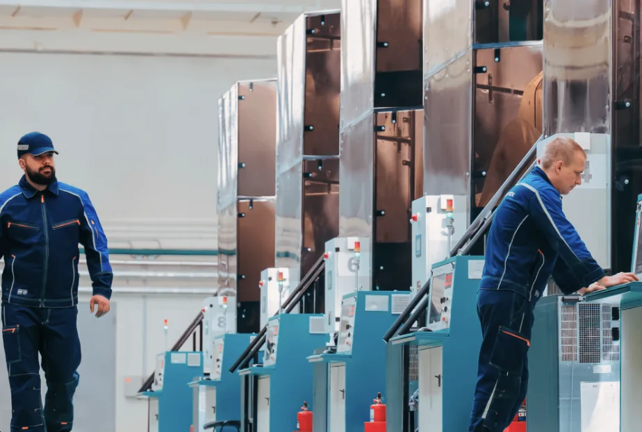 Operators at a row of HPHT cubic presses on the production floor