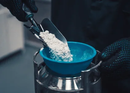 Powder being poured into a mixing vessel