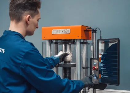 An operator loading a hydraulic press for cell parts